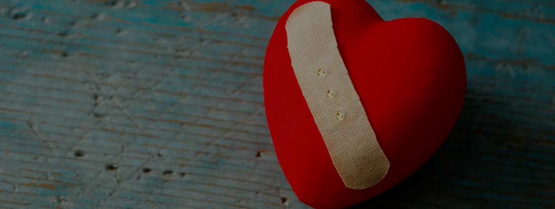 Red heart shaped pin cushion with plaster design across it
