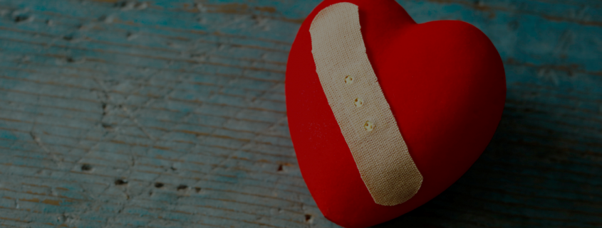 Red heart shaped pin cushion with plaster design across it